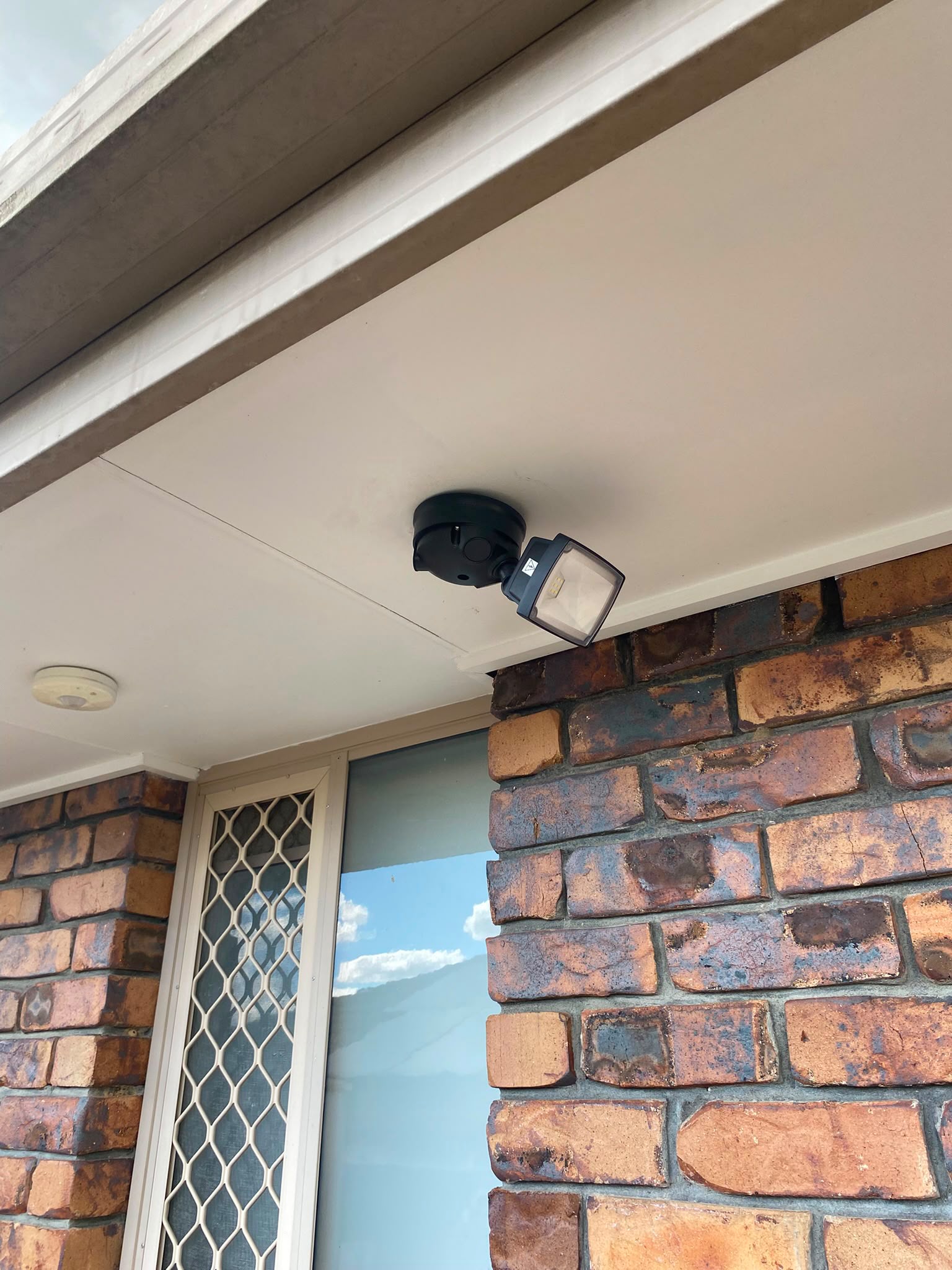 Outdoor security light installed under an eave